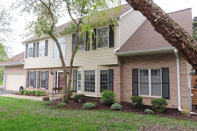 view of front of property with brick siding, an attached garage, a front lawn, roof with shingles, and driveway