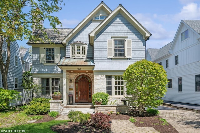 view of front of home featuring stone siding and fence