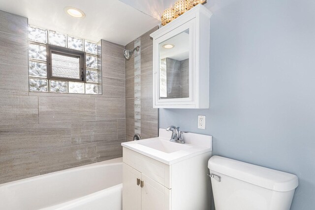 bathroom with vanity, tub / shower combination, and toilet