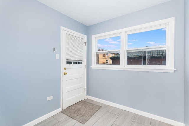 doorway featuring baseboards and wood tiled floor
