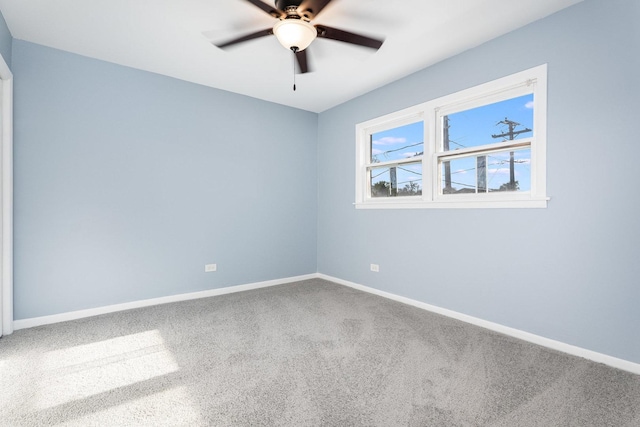 spare room with a ceiling fan, baseboards, and carpet