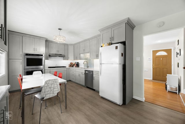4704 W 99th St, Oak Lawn, IL 60453 - kitchen with appliances with stainless steel finishes, gray cabinetry, under cabinet range hood, and wood finished floors