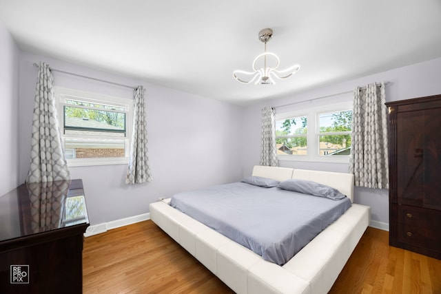 4704 W 99th St, Oak Lawn, IL 60453 - bedroom with a chandelier, multiple windows, and light wood finished floors