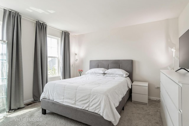 bedroom with light carpet and baseboards