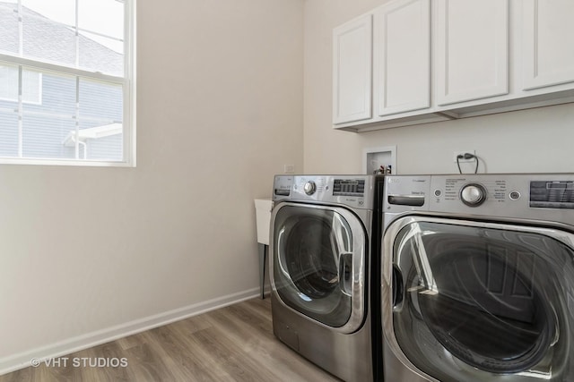 clothes washing area with independent washer and dryer, cabinet space, baseboards, and wood finished floors