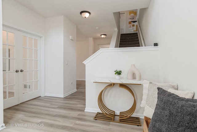 living area with french doors, wood finished floors, stairs, and baseboards