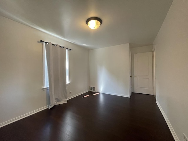 unfurnished room with dark wood-style floors and baseboards
