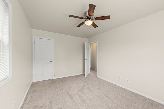 unfurnished bedroom with baseboards, light colored carpet, and a ceiling fan