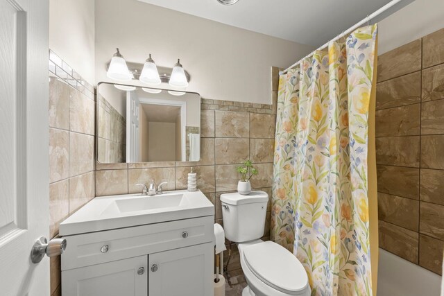 full bath featuring tile walls, toilet, vanity, and shower / tub combo with curtain