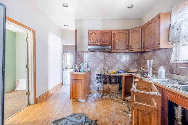 6835 S Winchester Ave, Chicago, IL 60636 - kitchen with tasteful backsplash, brown cabinets, light countertops, light wood finished floors, and under cabinet range hood