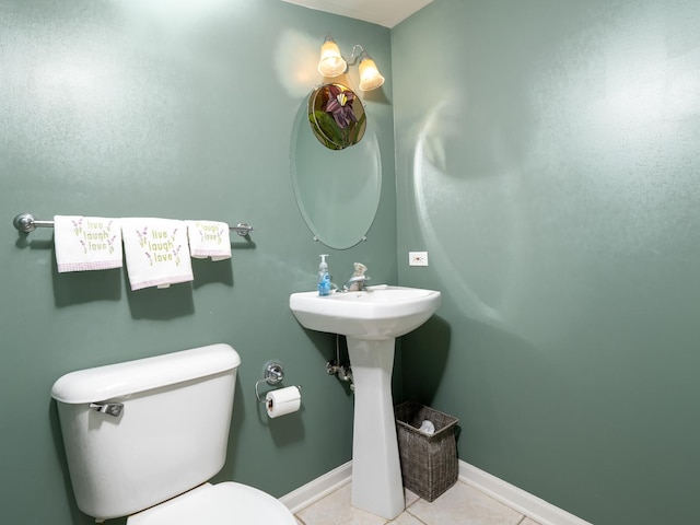 bathroom with baseboards, tile patterned floors, and toilet