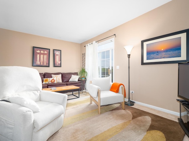 carpeted living area featuring baseboards
