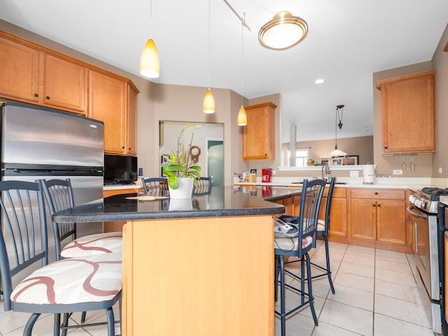 kitchen featuring a kitchen breakfast bar, a center island, stainless steel appliances, light tile patterned floors, and pendant lighting