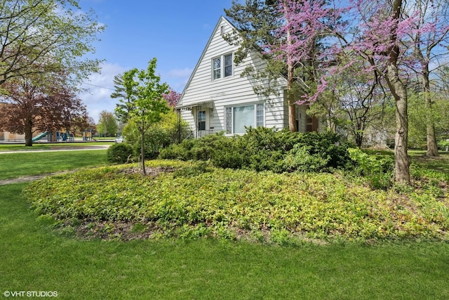 view of side of property with a playground and a yard