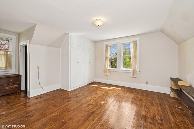 bonus room with lofted ceiling, hardwood / wood-style floors, and baseboards