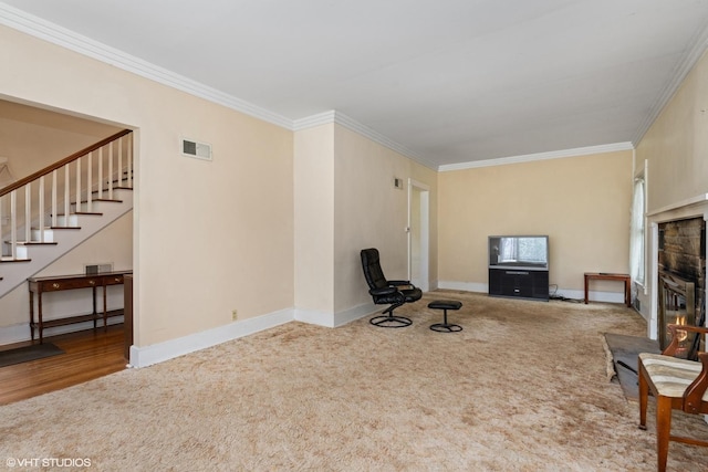 unfurnished living room featuring baseboards, ornamental molding, visible vents, stairway, and carpet floors
