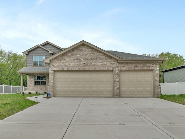 view of front facade featuring an attached garage, brick siding, driveway, and fence