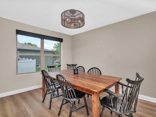 dining area with baseboards and wood finished floors