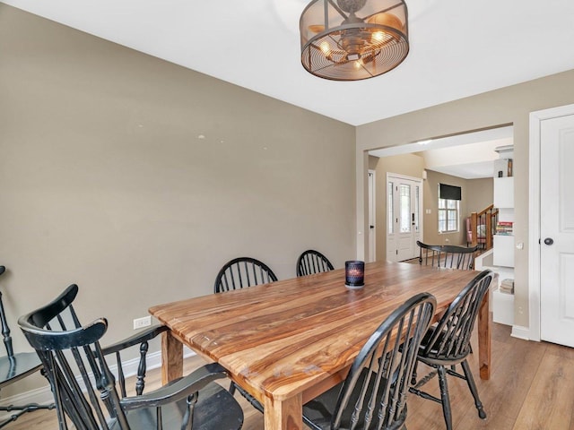 dining space with light wood-style flooring and baseboards