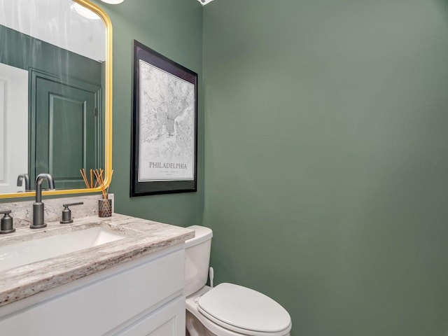 half bathroom with toilet and vanity