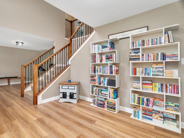 sitting room featuring stairway, baseboards, and wood finished floors
