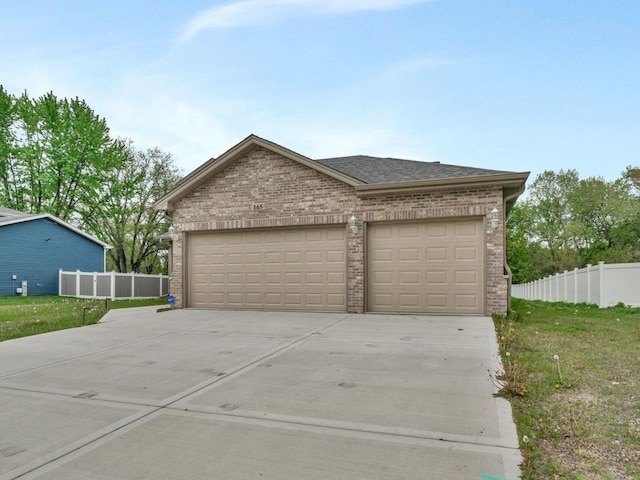garage featuring driveway and fence