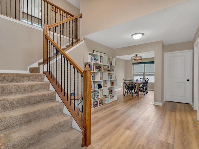 staircase featuring baseboards and wood finished floors