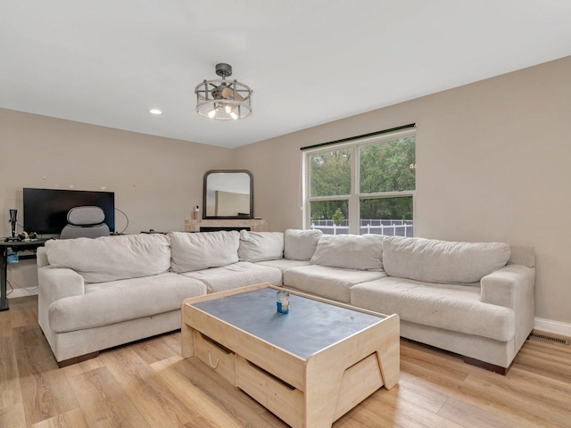 living room featuring light wood-type flooring, baseboards, and recessed lighting