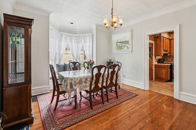 108 N Channing St, Elgin, IL 60120 - dining space with a chandelier, plenty of natural light, wood finished floors, ornamental molding, and baseboards