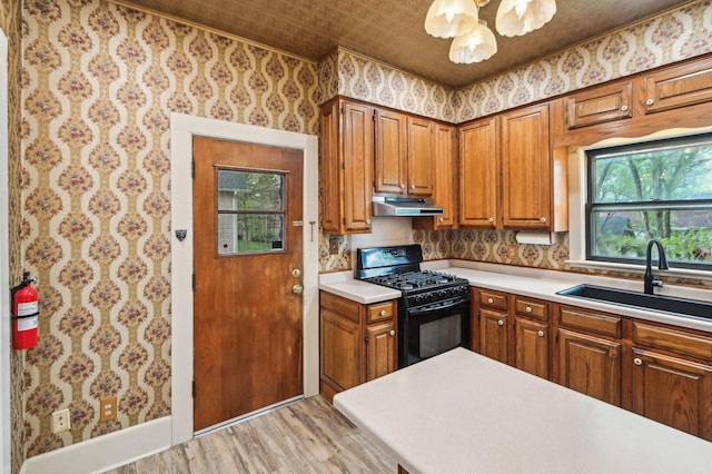 108 N Channing St, Elgin, IL 60120 - kitchen with black range with gas cooktop, under cabinet range hood, a sink, wallpapered walls, and light wood finished floors
