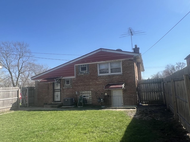 644 E 154th St, Dolton, IL 60419 - back of property with a chimney, central air condition unit, brick siding, a fenced backyard, and a yard