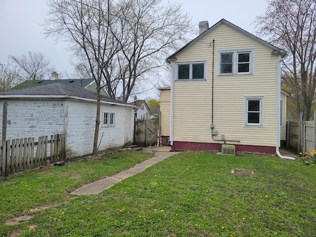 2811 Ezekiel Ave, Zion, IL 60099 - rear view of property with a fenced backyard, central air condition unit, a chimney, and a yard
