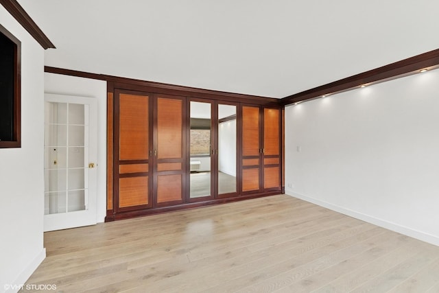 spare room with light wood-style floors and baseboards