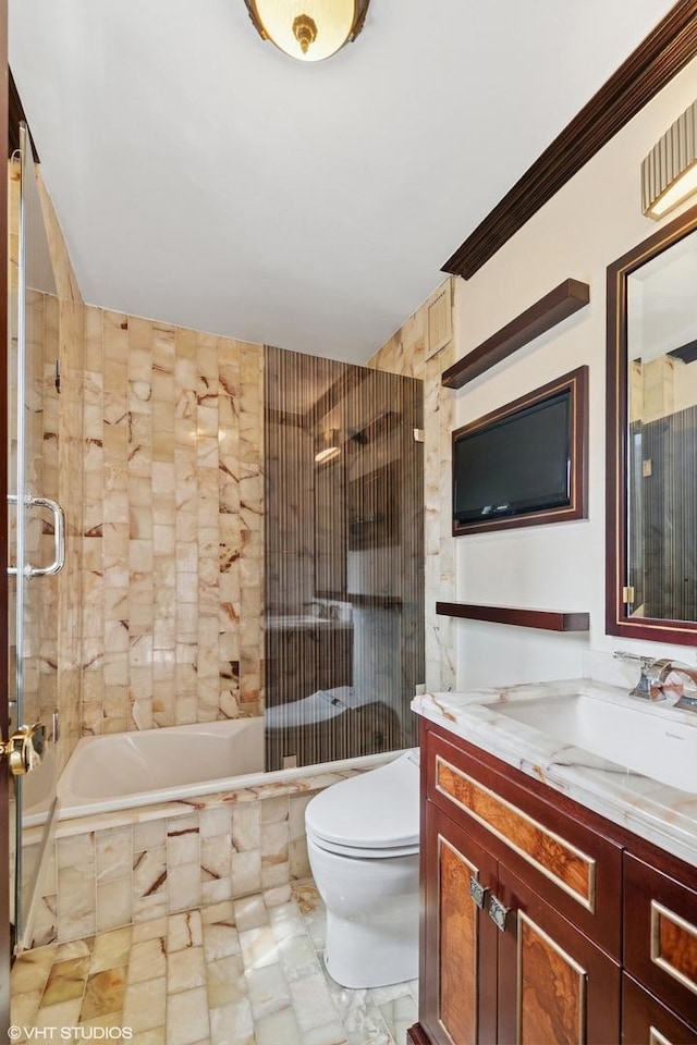 bathroom with vanity, tiled shower / bath, and toilet