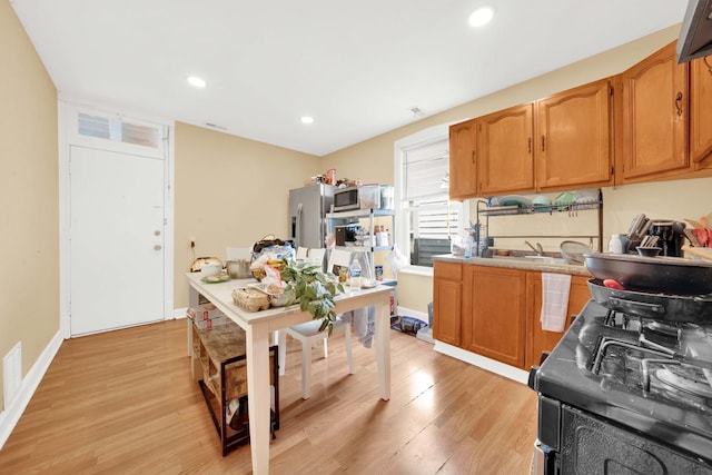 kitchen with recessed lighting, brown cabinetry, stainless steel appliances, and light wood finished floors