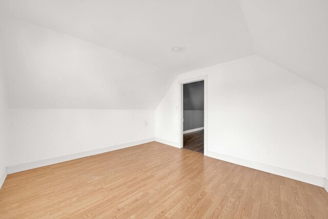 bonus room featuring baseboards, wood finished floors, and lofted ceiling