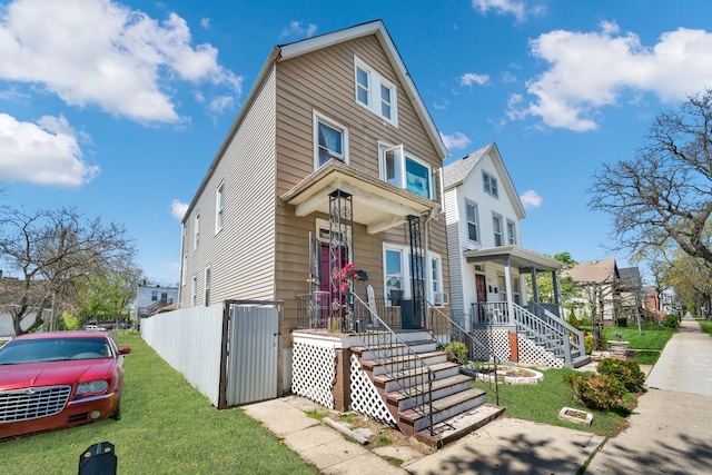 view of front of property featuring covered porch, a residential view, and a front lawn