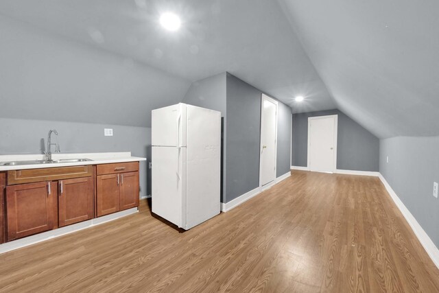 bonus room with baseboards, a sink, lofted ceiling, and light wood-type flooring
