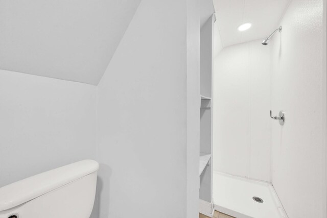 bathroom featuring toilet and a stall shower