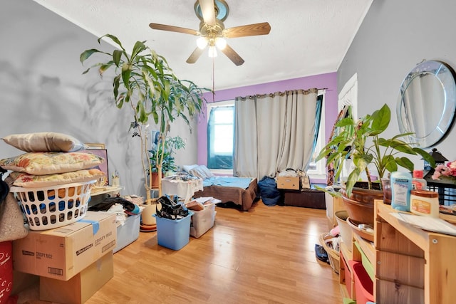 bedroom with a textured ceiling, light wood finished floors, and ceiling fan