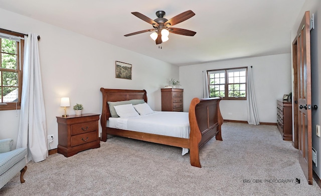 bedroom featuring light carpet, baseboards, and ceiling fan