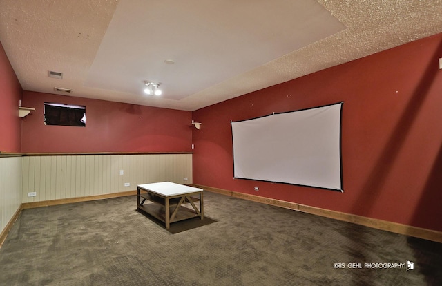 carpeted home theater with baseboards and a textured ceiling