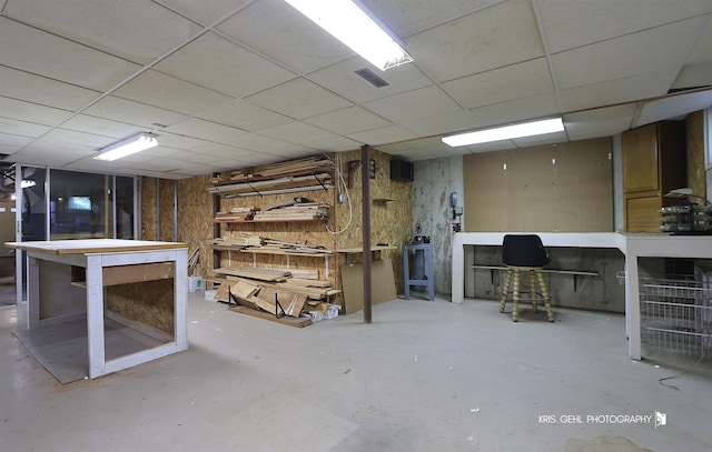 basement with a workshop area and a drop ceiling
