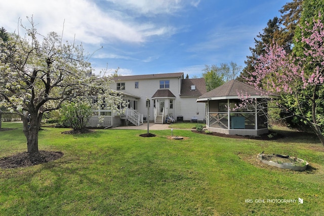 back of property with a sunroom and a lawn