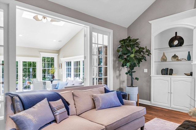living area featuring baseboards, recessed lighting, lofted ceiling with skylight, and wood finished floors