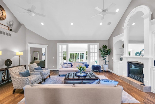 living area featuring recessed lighting, a glass covered fireplace, ceiling fan, and high vaulted ceiling