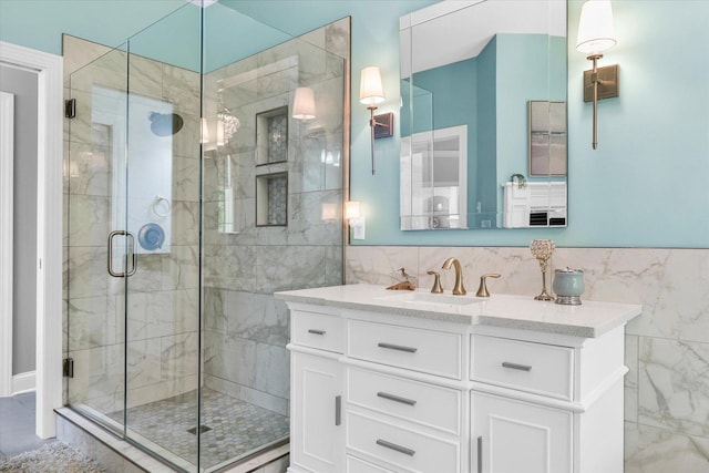 bathroom featuring vanity, a shower stall, and tile walls