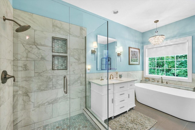 bathroom with a freestanding tub, tile walls, tile patterned flooring, a stall shower, and vanity
