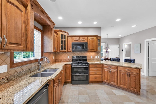 kitchen with a peninsula, glass insert cabinets, brown cabinets, a sink, and black appliances