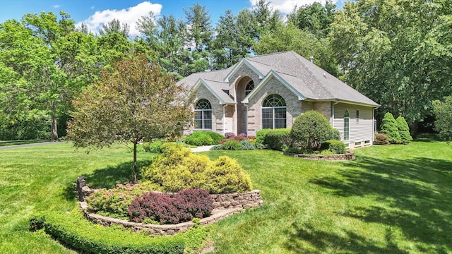view of front of home with stone siding and a front yard
